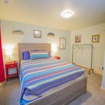 alternate view of bed with metal clothes rack and cute artwork of donkeys